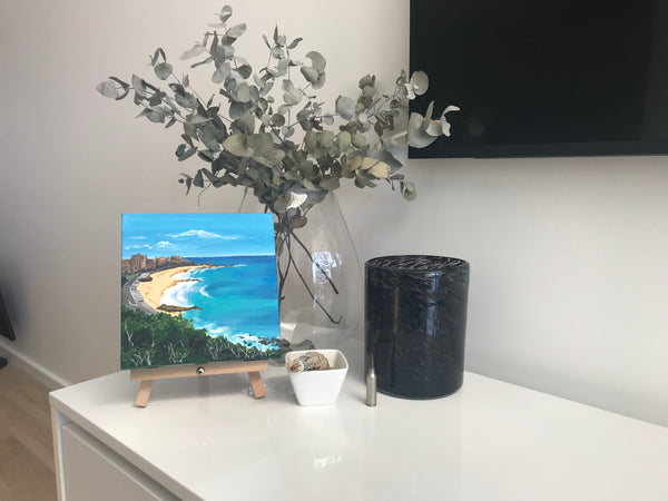 Newcastle Beach painting on easel in home setting